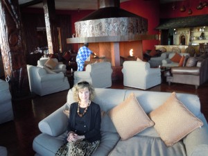 Sandi in the Sopa Lodge lounge, fireplace behind her